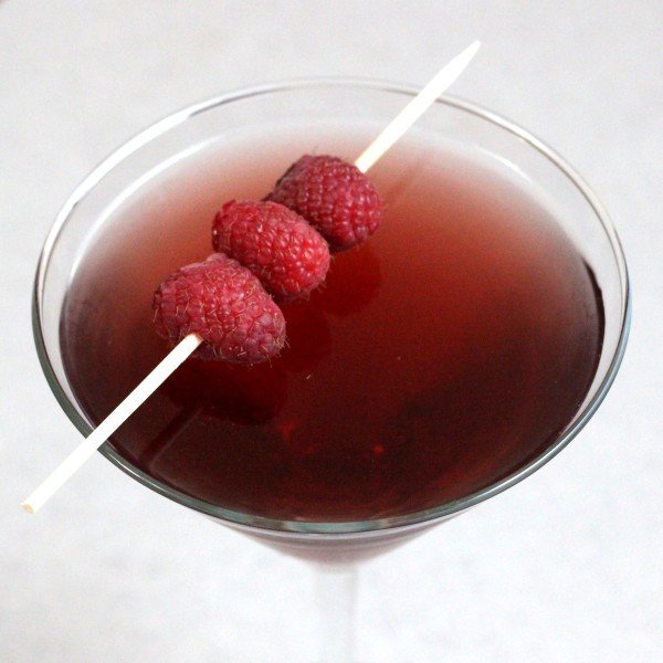 Overhead view of Raspberry Blush drink in cocktail glass with speared raspberries
