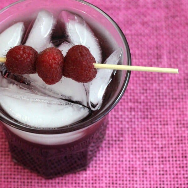 Overhead view of Raspberry Kamikaze drink with speared raspberries