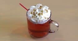 Red Rudolph cocktail with whipped cream and gold pearl sprinkles