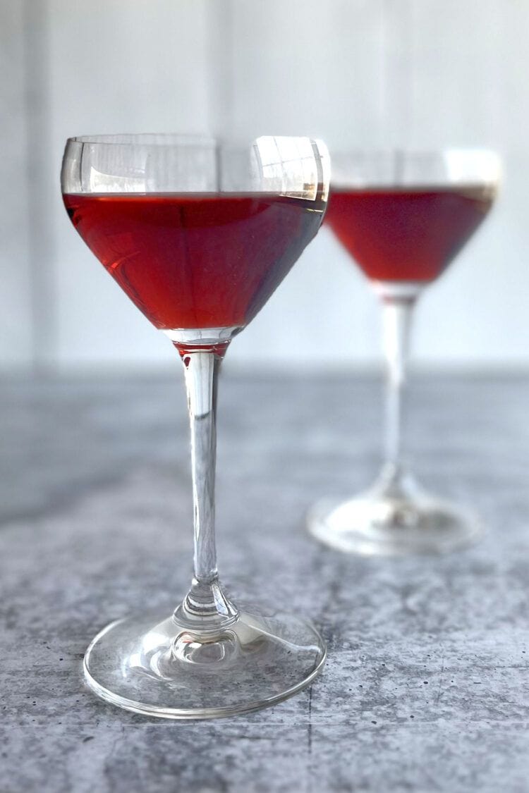 Two red wine cocktails in Nick and Nora cocktail glasses