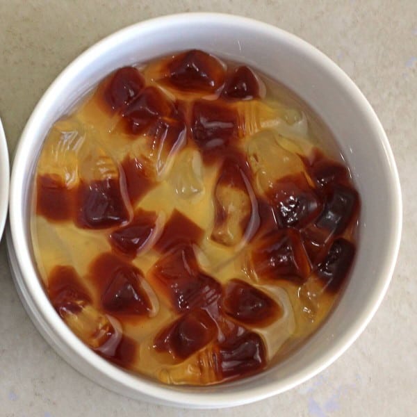 Cola gummies soaking in white bowl with rum