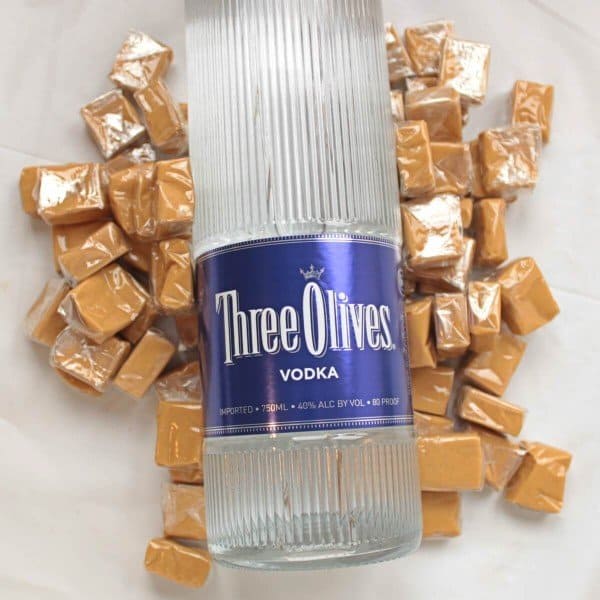 Bottle of vodka laying on caramel candies