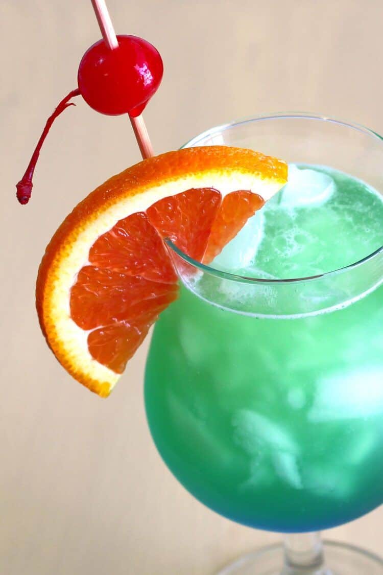 Closeup of Shamrock Juice cocktail with orange and cherry garnish