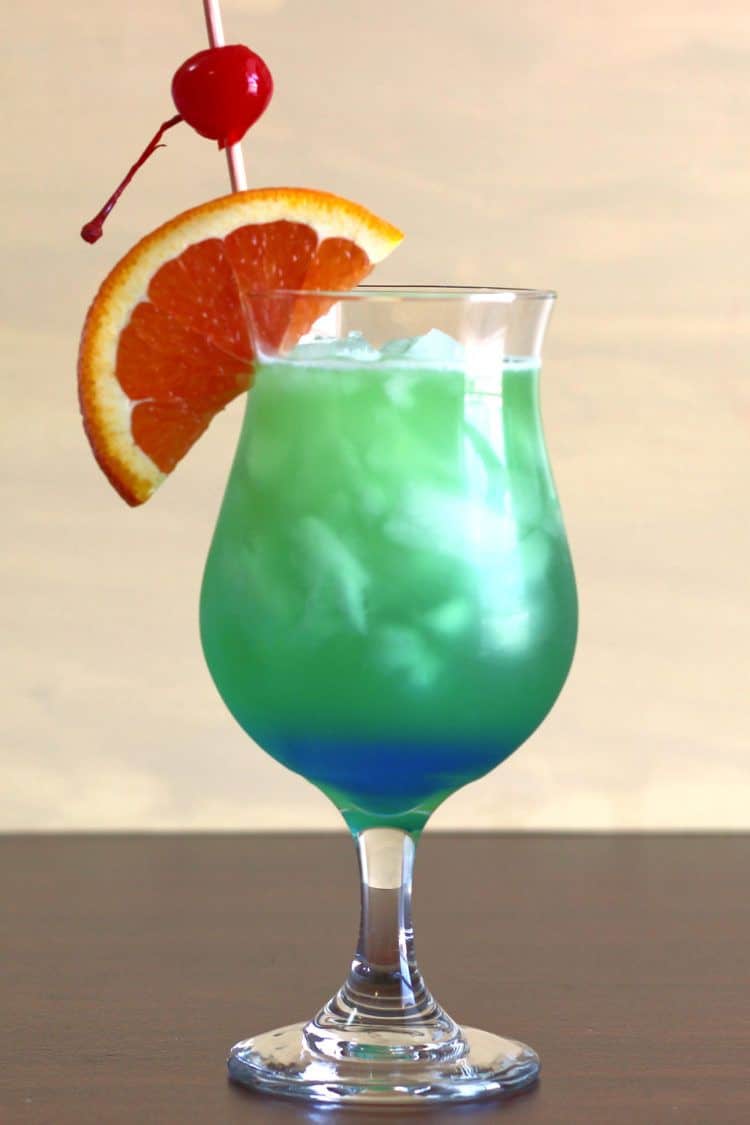 Shamrock Juice cocktail in hurricane glass with orange and cherry garnish