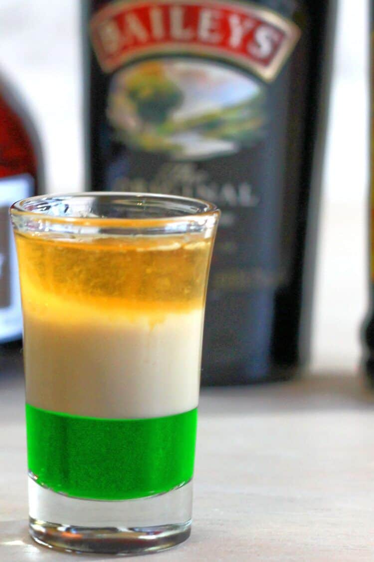 St. Patrick's Day cocktail on table in front of liquor bottles