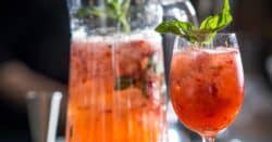 Strawberr Smash drink in glass next to pitcher of same