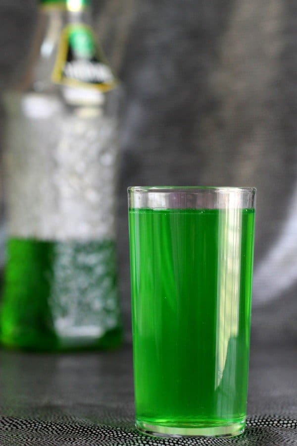 Sweet Tart drink in front of bottle of Midori