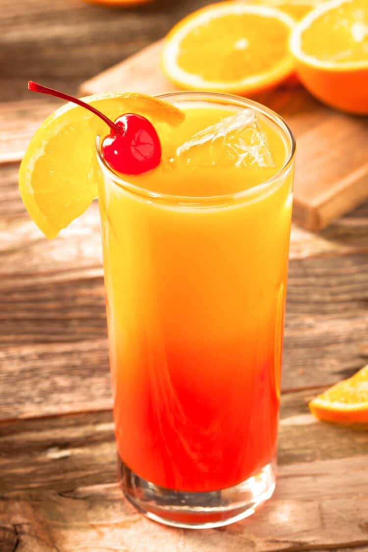 Tequila Sunrise with orange and cherry garnish