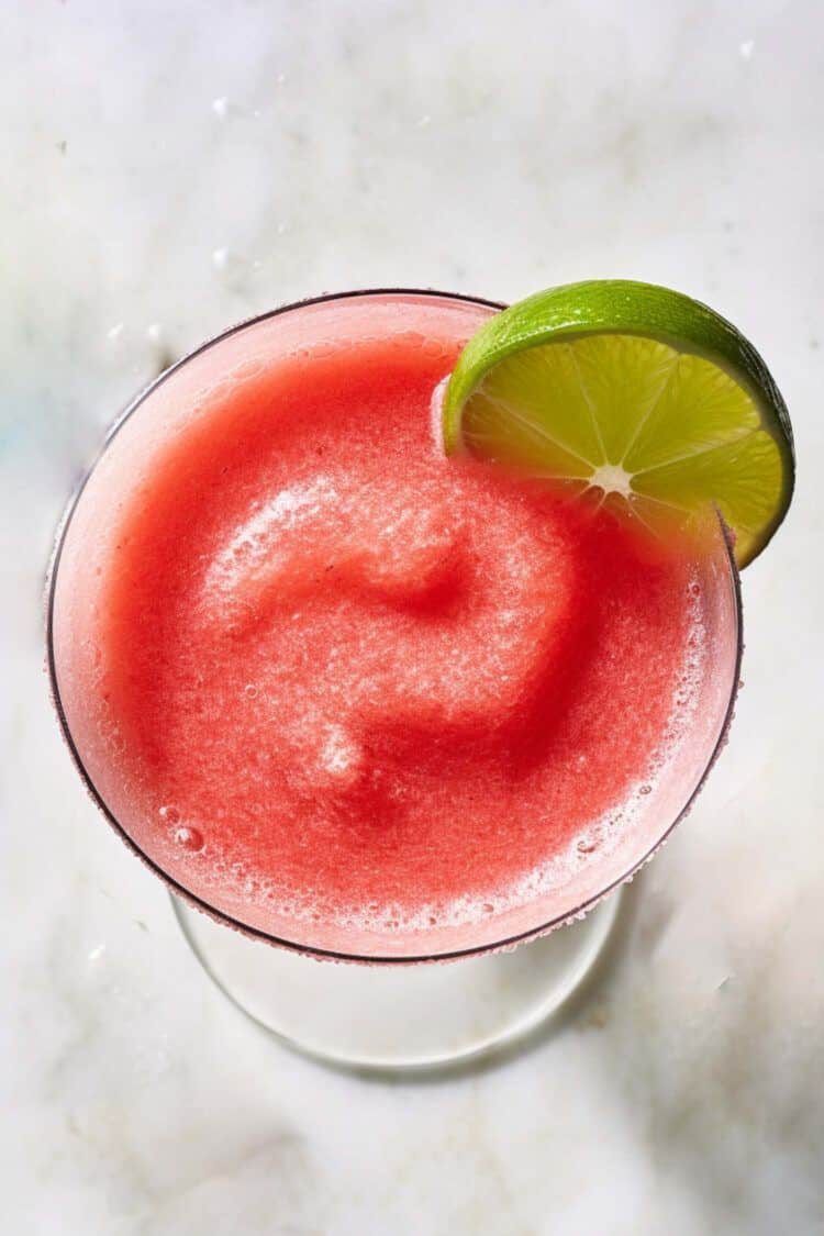 Overhead view of Triple-Berry Margarita with lime wedge garnish