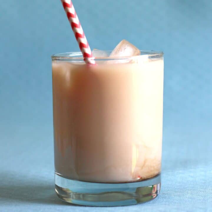 Velvet Hammer drink against blue background with striped red and white straw