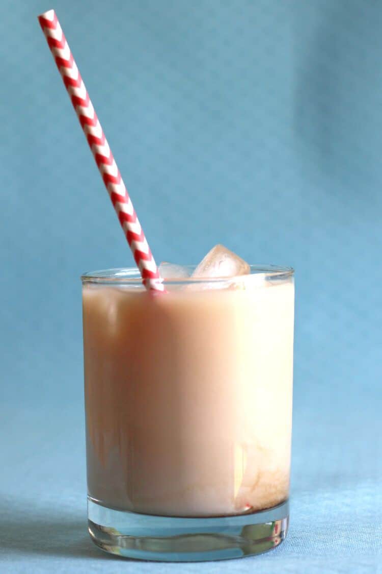 Velvet Hammer drink against blue background with striped red and white straw
