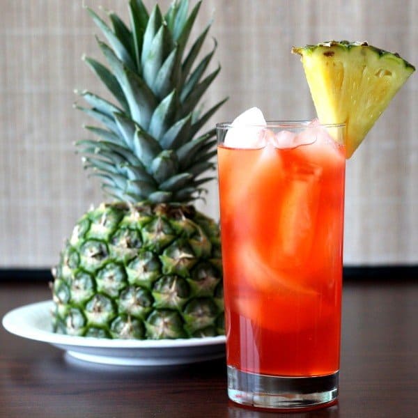 Full-length view of Western Sling drink next to pineapple on plate