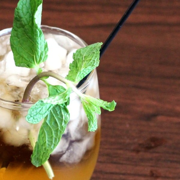 Closeup view of Whiskey Smash drink with mint sprigs