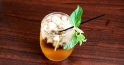 Whiskey Smash drink with mint sprigs