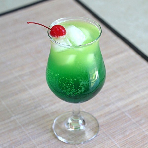 Bright green Zolezzi Cocktail with cherry served on placemat