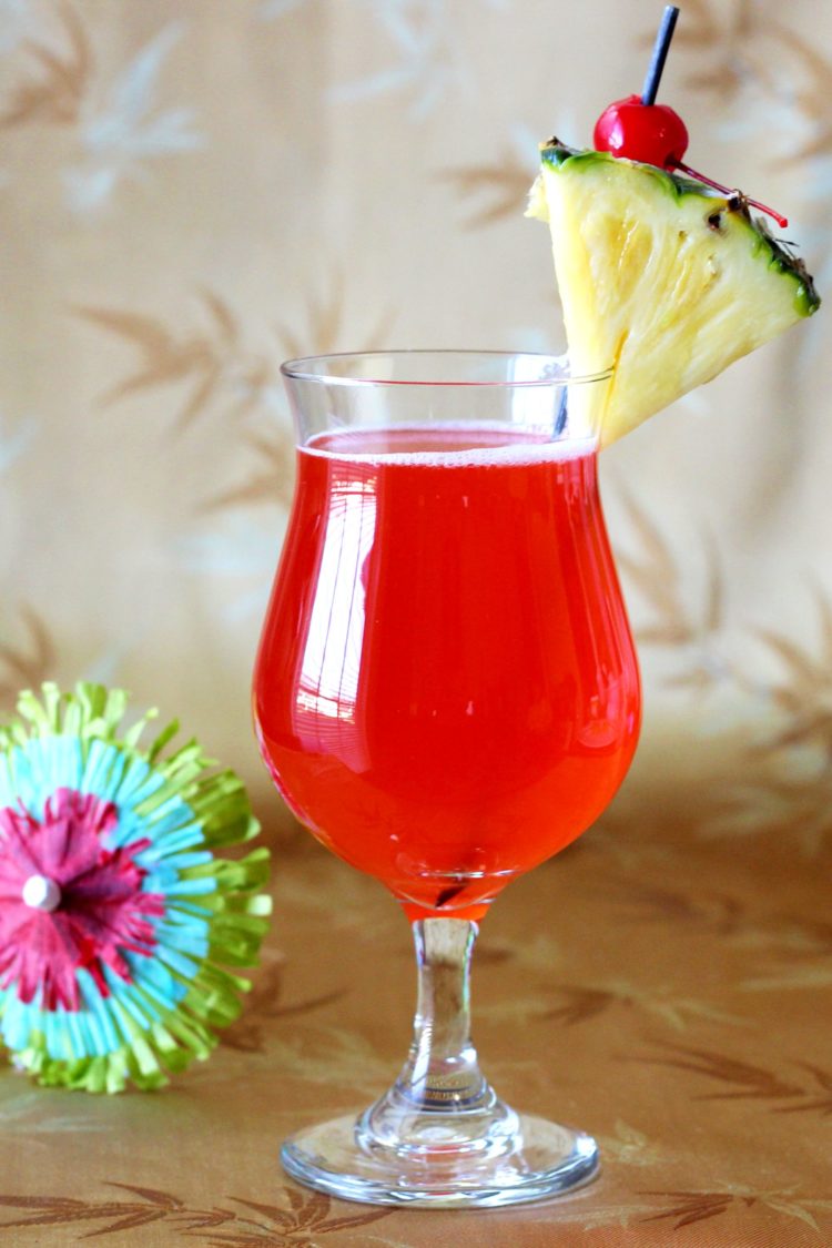 Zombie drink with pineapple and cherry against patterned backdrop
